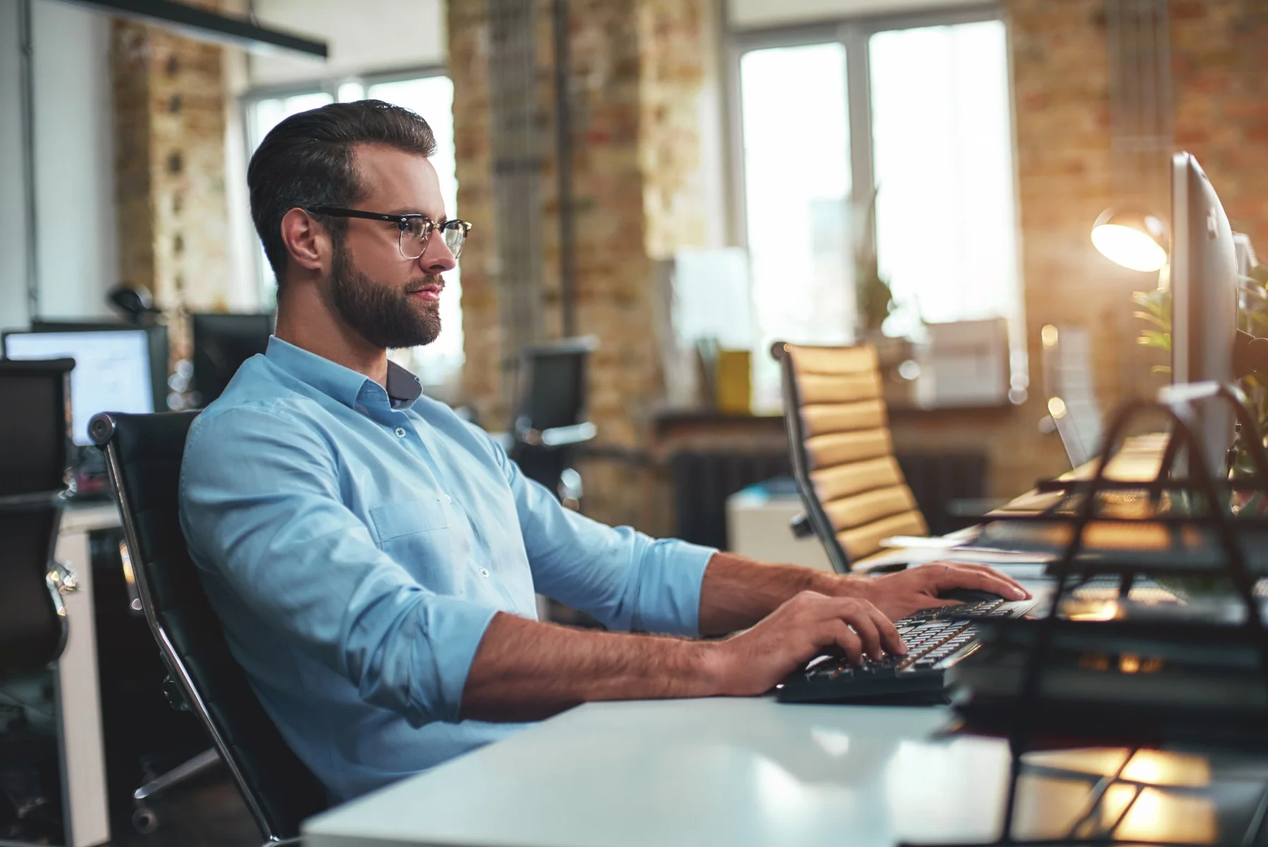 man wearing glasses using computer