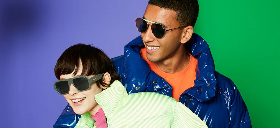 man and woman smiling multi coloured background wearing polaroid sunglasses in circular and thick acetate styles