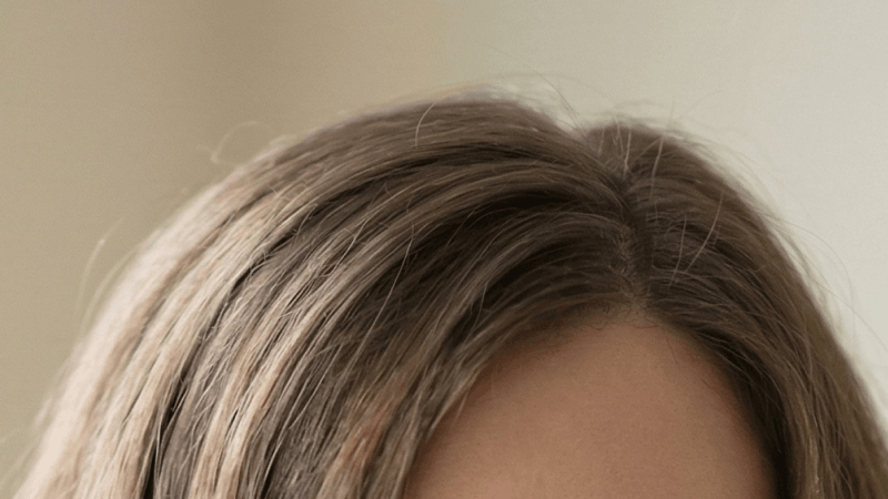 Person with brown hair wearing glasses