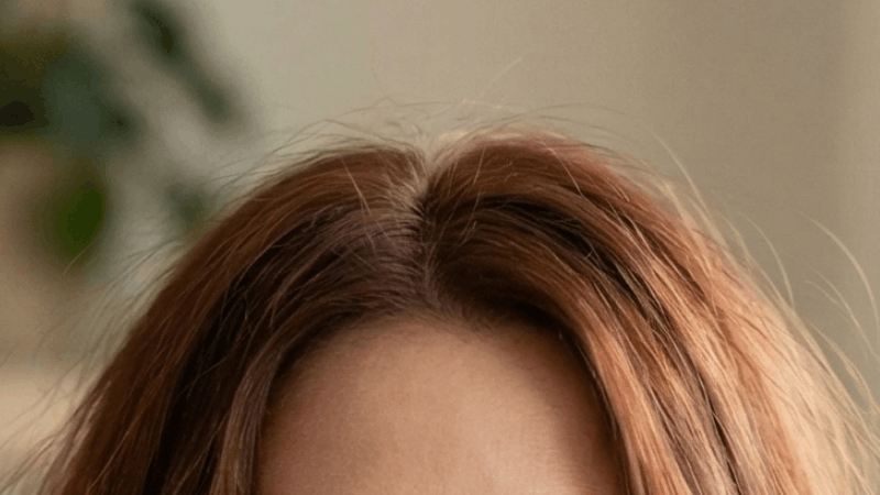 Person with red or auburn hair wearing glasses