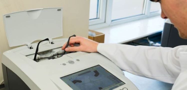 Lab technician using glasses blocking machine