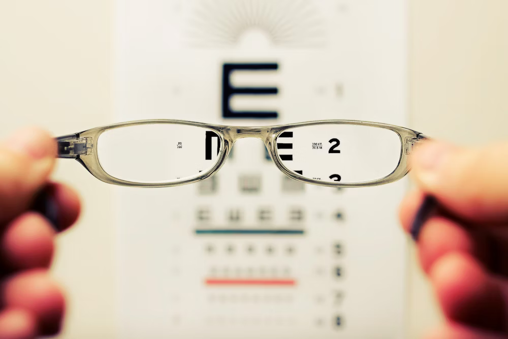 Professional working at computer desk with occupational lenses, showing comfortable vision for office work